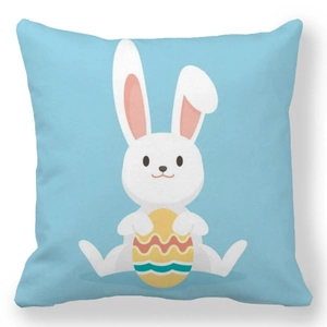 Detail of blue Easter pillowcase featuring a cartoon white rabbit holding a painted egg
