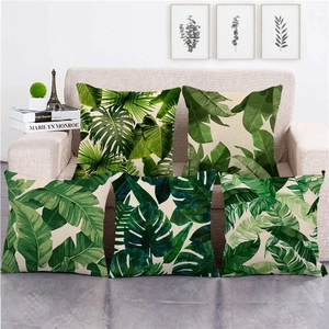 5-pack tropical monstera and palm leaf linen pillow covers on a beige sofa
