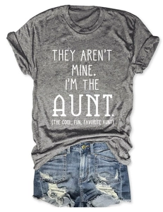 Flat lay of gray aunt theme t-shirt with blue distressed denim shorts on white background