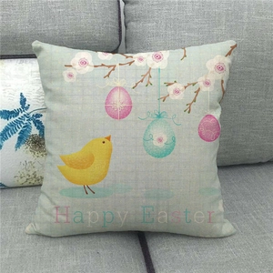 Close-up of Happy Easter linen pillowcase with bird and egg patterns on a grey sofa