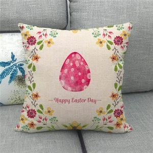 Close-up of Happy Easter linen pillowcase with pink egg pattern on a grey sofa