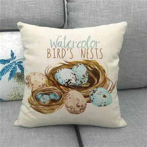 Detail view of linen Easter pillowcase with watercolor bird nests on a grey sofa