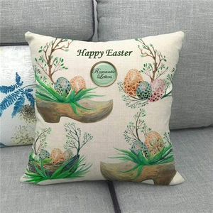 Detail of Happy Easter cushion cover with hand-painted eggs on a gray fabric sofa