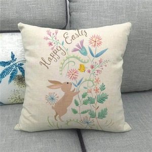 Detalle de funda de cojín de lino con conejo de Happy Easter y flores en sofá