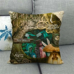 Detail of linen pillow cover with vintage Alice in Wonderland prints on a grey sofa