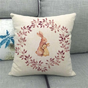 Easter rabbit linen pillowcase featuring cute hugging bunnies and floral wreath on sofa