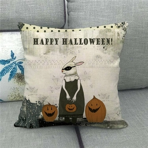 Linen Halloween pillow case with rabbit and pumpkin displayed on a grey sofa