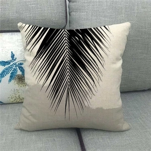 Close-up of tropical palm leaf print and textured linen fabric on a square cushion cover