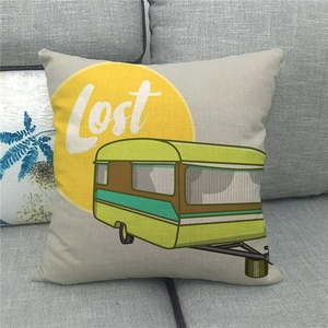 Close-up of linen pillowcase with retro green camper van and lost text on a sofa