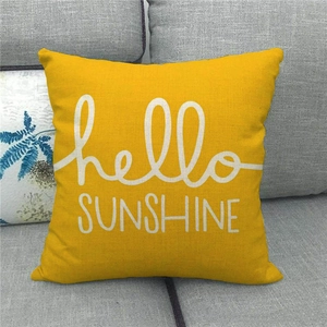 Detailed texture of yellow linen pillowcase featuring white hello SUNSHINE print