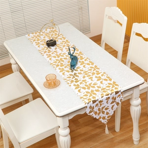 Christmas table runner with gold holly leaf patterns and elegant white tassels