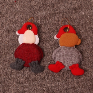 Close-up of plush Christmas ornaments featuring Santa and bear with golden hanging strings