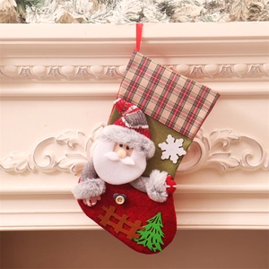 Grande calza di Natale festiva con Babbo Natale 3D e recinzione su un camino bianco