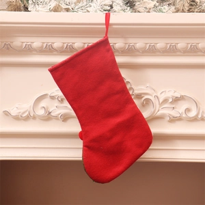 Dettaglio di una calza di Natale rossa con gancio su un camino bianco elegante