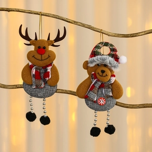 Detail of Christmas reindeer and bear plush ornaments hanging on a rustic wooden branch