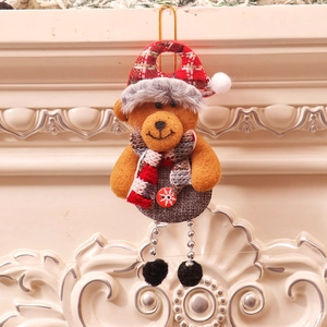 Close-up of plush Christmas bear ornament with red plaid hat hanging on fireplace