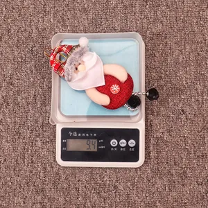 Detailed view of handmade Santa plush ornament weighing 9.4g on a digital scale