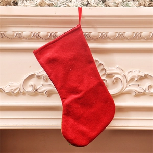 Classic large red Christmas stocking hanging on a white fireplace for festive decoration