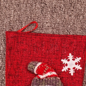 Close-up of red tweed Christmas stocking with snowflake patch and knitted trim detail