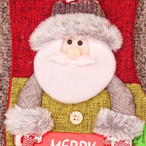 Close-up of Santa Claus 3D knitted Christmas stocking with white Merry text sign decoration