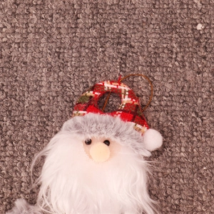 Detailed view of Santa plush ornament with red plaid hat and soft white beard detail