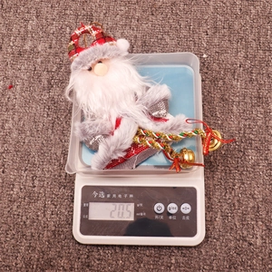 Detail of Santa plush ornament with red plaid fabric, faux fur, and a small golden bell charm