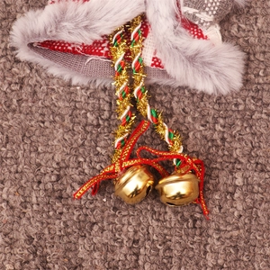 Detail of Christmas ornament featuring grey fur, plaid fabric and golden bells on a rope