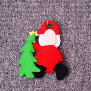Detail of handmade felt Santa Claus hanging ornament with mini Christmas tree and gold cord
