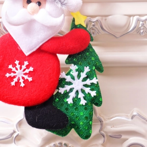 Detailed view of plush Santa Claus ornament holding a green sequin Christmas tree
