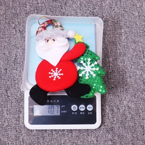 Detail shot of a dancing Santa and felt tree ornament being weighed on a scale