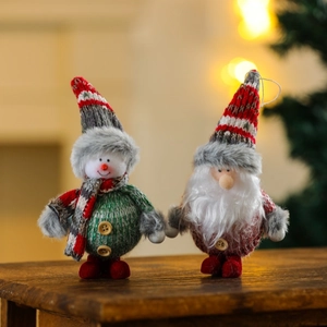 Detail of plush snowman and Santa ornaments with knitted textures on a wooden surface