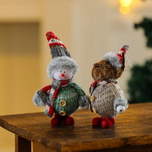 Close-up of plush Christmas ornaments with knit outfits and wooden buttons on wood