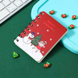 Close-up of portable red Christmas spiral notebook with snowman and girl illustration