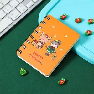 Detailed view of an orange Christmas notebook with reindeer and gingerbread illustrations
