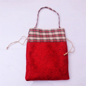 Detail of red felt Christmas gift bag with plaid trim drawstring and long handle
