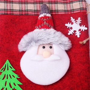 Detail of felt Christmas gift bag featuring 3D Santa Claus and plaid fabric trim