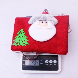 Detail shot of a red felt Christmas gift bag weighing 43.4g on a digital scale