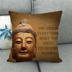 Detail of linen pillow cover featuring Buddha head print and inspirational quote on sofa