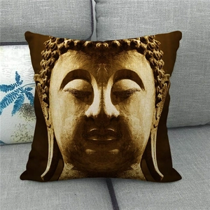 Detail of Buddha linen pillowcase showing golden head print on a modern grey fabric sofa