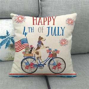 Detail of July 4th linen pillowcase with dog on bicycle pattern on a gray sofa