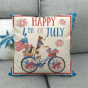 Linen Independence Day pillow cover featuring a festive dog on bike on a grey sofa