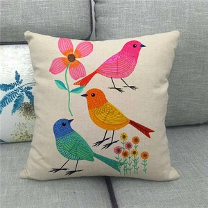 Linen throw pillow cover featuring cute cartoon birds and floral patterns on a gray sofa