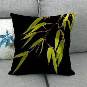 Detailed macro view of green bamboo leaves print on black linen throw pillow case