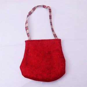 Detail of red felt Christmas candy bag with red and black checkered woven handles