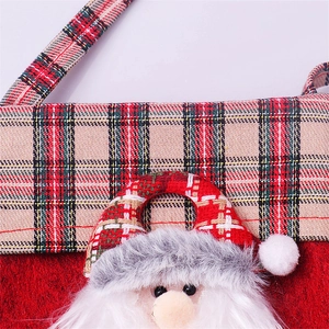 Detailed macro view of festive Christmas stocking bag with plaid trim and Santa Claus motif