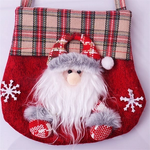 Detail of red felt Christmas gift bag featuring a 3D Santa Claus and plaid handle strap
