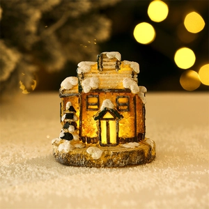 Detail of miniature resin Christmas house with LED lights and snow effect on base