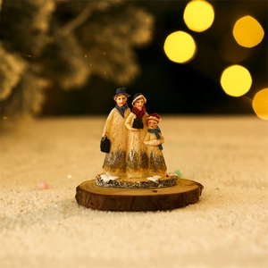 Detail of hand-painted resin Christmas family figurines with snow base decor