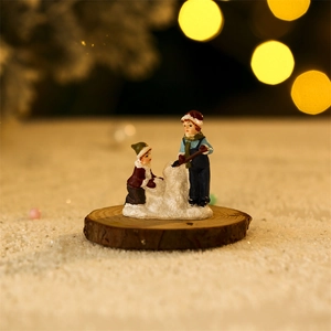 Close-up of resin winter figurines showing a boy and girl building a snowman