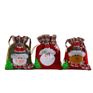 Three Christmas drawstring gift bags featuring snowman, Santa and reindeer patterns